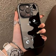 a woman's hand holding an iphone case with a black cat on it