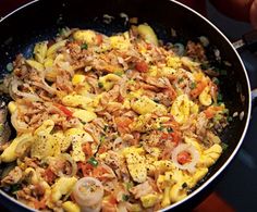 a pan filled with pasta and vegetables on top of a stove