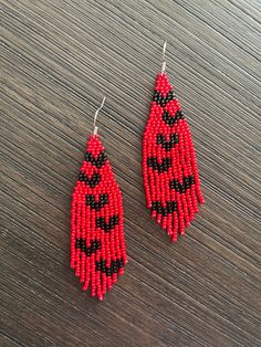 red and black beaded earrings on wooden table