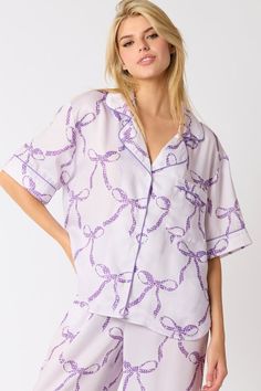 Peach Love California Light purple satin button down pajama top with dark purple bow tie print Purple Sleepwear For Spring Pajama Party, Purple Sleepwear For Pajama Party In Spring, Spring Purple Satin Top, Purple Satin Top For Spring, Purple Short Sleeve Sleepwear For Pajama Party, Casual Purple Top For Bedtime, Purple Satin Sleepwear, Spring Satin Sleep Top, Purple Sleep Tops For Spring