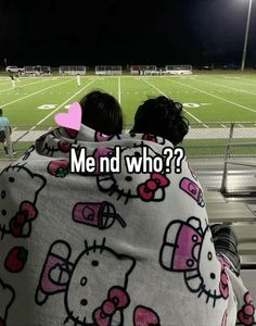 two people wrapped up in blankets with hello kitty on them at a soccer field, and the caption reads me nd who?