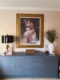 a painting hangs on the wall above a dresser