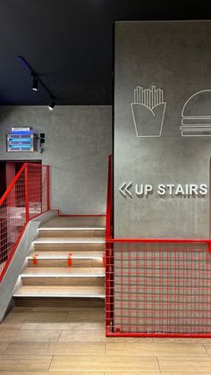 the stairs are red and white in this modern office building with an up stairs sign on the wall