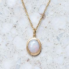 A milky crystal opal has been set into our classic matte gold bezel. Opal measures 10 x 8 mm oval. Weight without chain 2.5g approx. Trace chain measures 45cm. Pictured with a matte finish. For a high shine finish, please leave a note at checkout. Please note, we will match the opal as close to the image as possible. Each opal is unique and may vary in appearance and colour from what is depicted on the site. Yellow Gold Opal Oval Necklace, Oval Opal Necklace In Yellow Gold, Yellow Gold Oval Opal Necklace, Oval Yellow Gold Opal Necklace, White Oval Opal Necklace, Gold Opal Necklace With Oval Cabochon, 14k Gold Oval White Necklace, 14k Gold Oval Necklace In White, White Oval 14k Gold Necklace