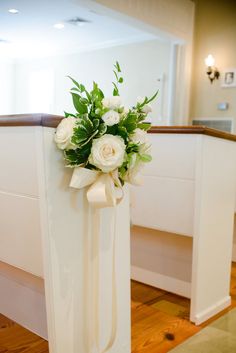 a bouquet of white flowers sitting on top of a wooden banister