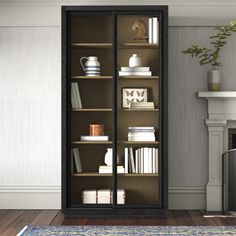 a bookcase with many books in it next to a fireplace