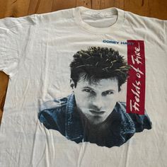 a white t - shirt with an image of a young man's face on it