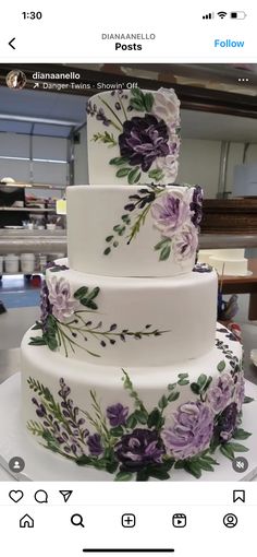 a three tiered cake with purple flowers on it