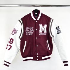 A symbol of school spirit and authentic Morehouse cool, the varsity jacket is an iconic LegacyHistoryPride silhouette. The details on the sleeves with the "TIGER" mascot and "1867" along with "The HOUSE" motto on the back screams school pride with a sporty style. It’s crafted in wool with leather sleeves and pockets, and finished with signature striped ribbed trim. Men - Order up a size if you don't like the fitted snug look. Women - Women's Large will fit the LHP Medium Dry Clean Only Varsity Jacket Design Ideas, Senior Jackets, Letter Jacket, School Jacket, Graduation Picture, Graduation Picture Poses, Varsity Jackets