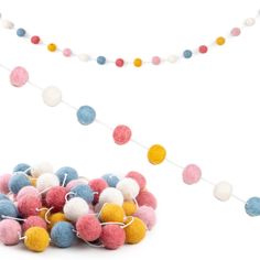 a bunch of pom - poms on a string next to a white background