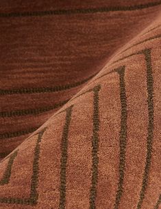 a close up view of a brown and black rug with lines on the floor,