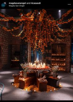 a table with candles and flowers on it in the middle of an indoor space that is lit up