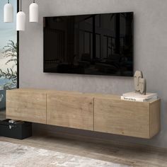 a large flat screen tv mounted to the side of a wooden cabinet in a living room