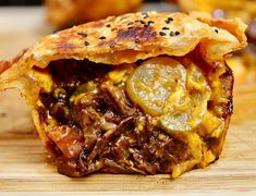 a close up of a food item on a cutting board with other foods in the background