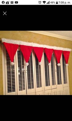 a window with red curtains and white shutters