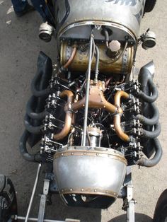 the engine of an old motorcycle is shown from above, with other parts attached to it