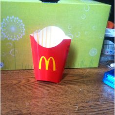 a mcdonald's cupcake sitting on top of a table next to a box