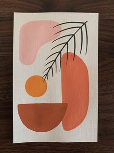 an orange and pink abstract painting on white paper with green leaves in the center, sitting on a wooden surface