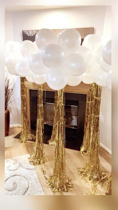 white and gold balloons in front of a fireplace