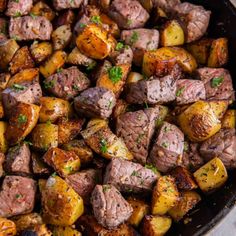 cooked meat and potatoes in a skillet with parsley on top, ready to be eaten