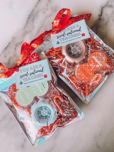 two packages of red and white candies on a marble counter top with ribbon tied around them