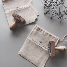 two small bags with wooden handles are sitting on a table next to some flowers and other items