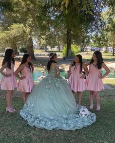 a group of women standing next to each other in front of a tree with flowers on it