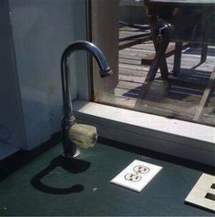 a bathroom sink sitting on top of a green counter next to a wooden floor and window