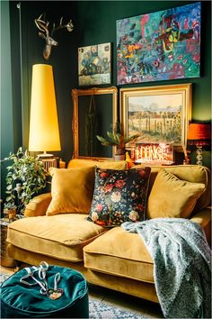 a living room filled with furniture and paintings on the wall