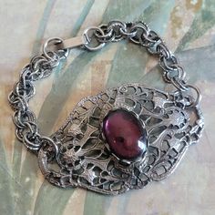 This is a vintage, silver tone metal and glass cabochon, bracelet. There is some wear to the cabochon, as you can see in the images. All sales are final. This measures 7 inches in length. The decorative part is just over 2 and 1/8 inches across.  If you have a wish list or are looking for something specific, please ask. I may have exactly what you are looking for. As always please convo me with any questions or concerns regarding this item or with any international shipping questions. Unfortunately I do not accept returns or grant refunds. All shipping fees include handling fees. If you would like to combine shipping costs for more than one item, I would be happy to do so if you convo me before purchase. Purchasing my item means you have read, understood and will abide by my policies. Sorr Antique Silver Cabochon Bracelets, Silver Metal Bracelet With Cabochon, Vintage Cabochon Bracelets As Gift, Vintage Cabochon Bracelet Gift, Silver Metal Bracelets Vintage, Vintage Cabochon Bracelets, Vintage Nickel-free Bracelets For Formal Occasions, Victorian Silver Bracelets With Jewels, Vintage Silver Pewter Jewelry