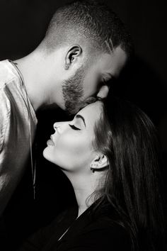 a man and woman kissing each other in black and white