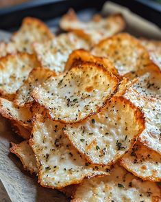 crispy baked potato chips on a wooden cutting board with seasoning sprinkled on top