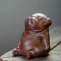 a chocolate seale sitting on top of a wooden table with its eyes closed and mouth wide open