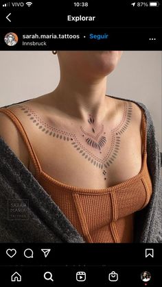 the back of a woman's chest with an intricate tattoo on her left shoulder