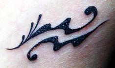 a small tattoo on the side of a woman's arm that is black and white