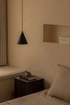 a lamp hanging over a bed next to a window