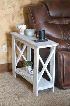 a small table with a coffee cup on it next to a recliner and couch