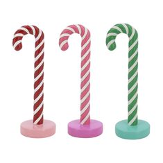 three candy canes sitting on top of each other in front of a white background