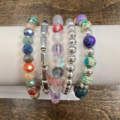 Add a sparkle to your style with Abby's Silver Colour Bracelet Stack! This gorgeous stack of bracelets feature a rainbow of beautiful colors, making it the perfect accessory for any outfit! It's sure to bring a pop of colour to your day! *please note: these bracelets are handmade and the beads vary in colors and shades. You will not receive the exact bracelets that are shown. If you are a HOC client, you can message us with your season and we will do our best to make your bracelet with at least 80% of your colors. Sterling Silver Stacker (#731) Meadow with Silver Charm Silver Rectangle Barrel (#970) Silver Ainsley HOC-Winter/Summer Stacked Bracelets With Round Beads, Stackable Multicolor Jewelry, Bohemian Multicolor Stacked Beaded Bracelets, Multicolor Stackable Wrap Bracelet, Multicolor Spiritual Stackable Jewelry, Bohemian Stacked Multicolor Jewelry, Multicolor Crystal Bracelet With Jubilee Style And Round Beads, Multicolor Stackable Round Beads Jewelry, Multicolor Stacked Round Beads Jewelry