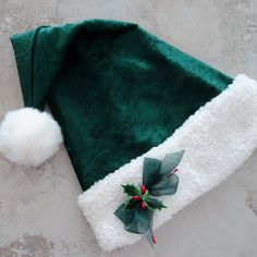 a green and white christmas hat with pom - poms