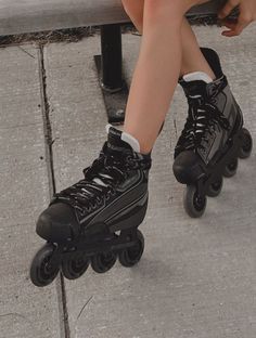 a person sitting on a bench with roller skates in front of their legs and feet