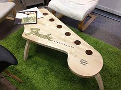 a table made out of a guitar pickle board on top of green carpeted area