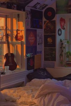 a bedroom with a guitar hanging from the ceiling next to a window and bed in front of it