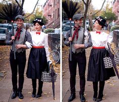 two people dressed in costumes and holding umbrellas on the sidewalk, one wearing a top hat