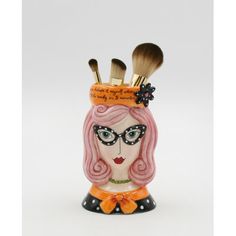 a ceramic brush holder with makeup brushes in the shape of a woman's head