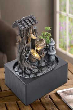 a bonsai tree in a black box on a wooden table