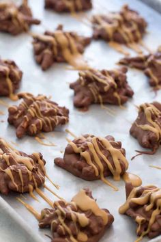 chocolate covered cookies with caramel drizzled on top are sitting on a baking sheet