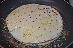 a tortilla being cooked in a frying pan