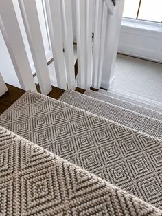 the carpet on the stairs is beige and has an interesting diamond pattern that matches with the white railing