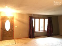 an empty room with a door, window and rug on the floor in front of it